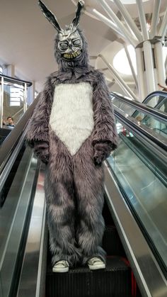 a person in bunny costume riding an escalator