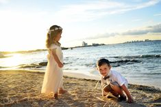 two children playing in the sand at the beach