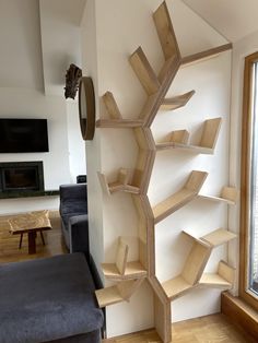 a living room filled with furniture and a tall book shelf next to a large window