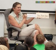 a woman sitting in a chair holding up a sign