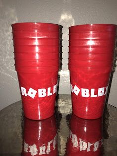 two red cups sitting on top of a table with the words robb written on them