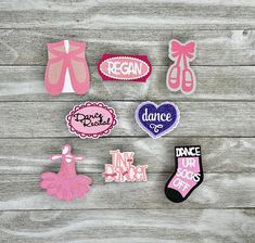 various patches and magnets on a wooden surface with pink bows, ballet shoes, and dancer's socks