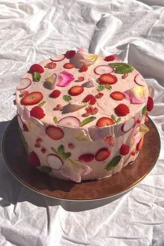 a cake with strawberries and radishes on it is sitting on a plate