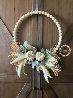 a wreath with flowers and feathers hanging on a door