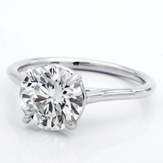 a round cut diamond in a white gold ring on a white background with clippings to the side