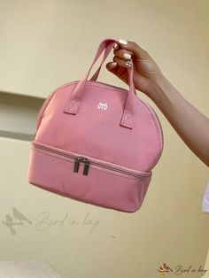 a woman is holding a pink bag with the initials on it and has her hand out