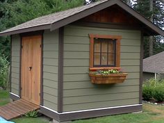 a small shed with a window and flower box