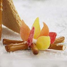 a small piece of food sitting on top of snow covered ground next to a slice of bread