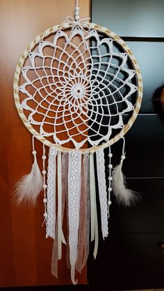 a white dream catcher hanging from the side of a door