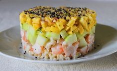 a white plate topped with rice covered in fruit and vegtables on top of it