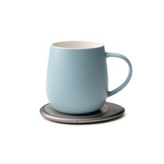 a blue coffee cup sitting on top of a saucer with a silver plate underneath it