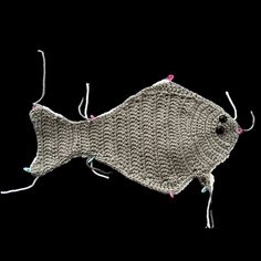 a knitted fish on a black background