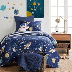 a child's bedroom with space themed bedding