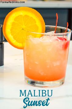 a close up of a drink in a glass with an orange slice on the rim