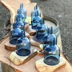 several blue glass vases sitting on top of a wooden table next to each other