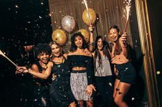 group of young women celebrating with sparklers and confetti in front of them