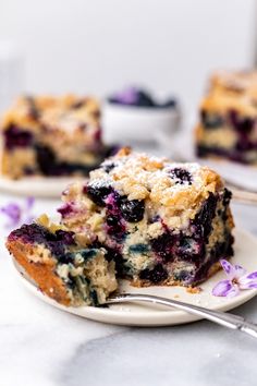 a piece of blueberry crumb cake on a plate with a fork next to it