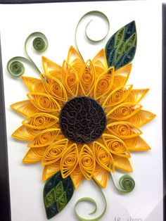 a yellow and green paper sunflower with swirls on it's back side