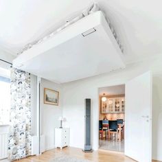 a living room filled with furniture and a white rug on top of a hard wood floor