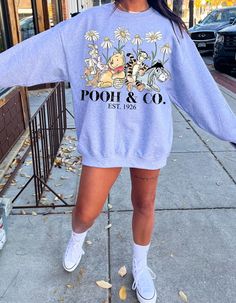 Wrap yourself in the charm of the Hundred Acre Wood with our "Pooh & Co. Cuddle Crewneck." This delightful sweatshirt invites you into the heartwarming world of Winnie the Pooh and his friends. Crafted from cozy materials, it provides the perfect blend of comfort and nostalgia. Embrace the whimsy of Pooh, Piglet, Eeyore, and Tigger as they adorn this charming crewneck. The playful design captures the essence of friendship, joy, and the simple pleasures of life. The crewneck's soft fabric ensures a snug fit, making it an ideal companion for chilly days or cozy nights in. Indulge in the timeless appeal of Disney's beloved characters and relive the magic of childhood with every wear. Whether you're a fan of the original stories or the animated adaptations, this "Pooh & Co. Cuddle Crewneck" is Winnie The Pooh Disney Outfits, Winnie The Pooh Disneybound, Pooh And His Friends, The Hundred Acre Wood, Piglet Eeyore, Pooh Piglet, Disney Sweatshirts, Pooh Bear, Mickey Mouse And Friends