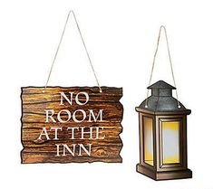 no room at the inn sign and lantern hanging from string with wood planks on white background