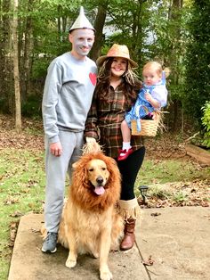 a man, woman and child are dressed up as scarecrows with a dog