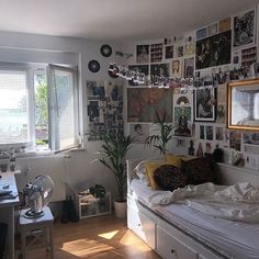 a bed sitting in a bedroom next to a window filled with pictures on the wall