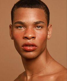 a young man with freckles on his face and chest looking at the camera