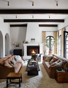 a living room filled with furniture and a fire place in the middle of a room