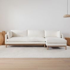 a white couch sitting on top of a hard wood floor next to a wooden table