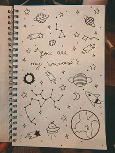 an open notebook with doodles on it and space related drawings all over the page