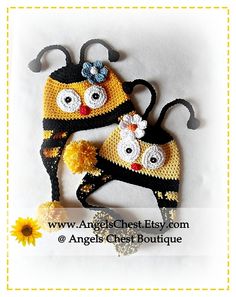 two crocheted hats with eyes and flowers on the top, one is yellow