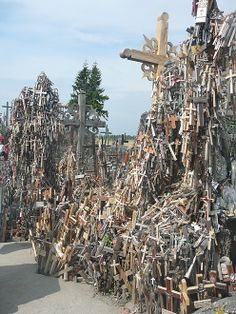 a large pile of wooden crosses sitting next to each other