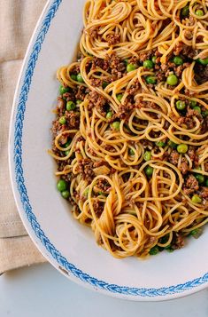 a white plate topped with spaghetti and meat