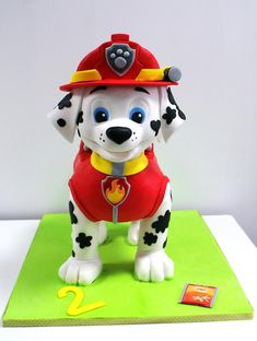 a cake shaped like a dog wearing a fireman's hat