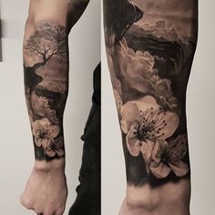 a man's arm with flowers and clouds on it