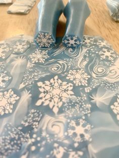 a pair of blue shoes sitting on top of a table covered in snowflakes