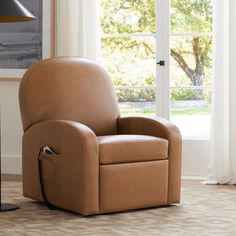 a brown recliner chair sitting in front of a window