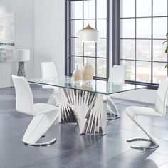 a glass dining table with white chairs around it