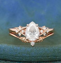 an engagement ring with a pear shaped diamond in the center and two diamonds on each side