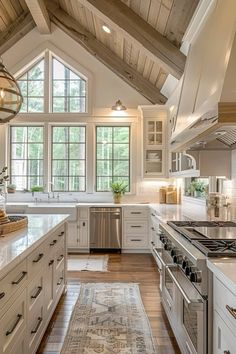 a large kitchen with white cabinets and wooden ceilinging, along with an area rug on the floor