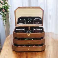 an open wooden jewelry box sitting on top of a table