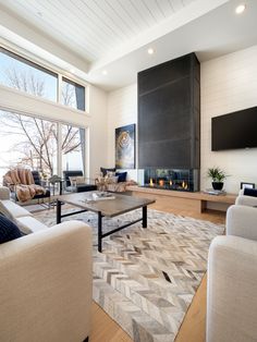 a living room filled with furniture and a flat screen tv mounted on the wall above a fireplace