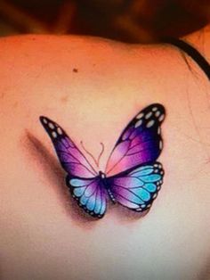 a woman's back with a butterfly tattoo on her shoulder and the bottom part of her stomach