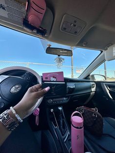 a woman is holding her cell phone in the car