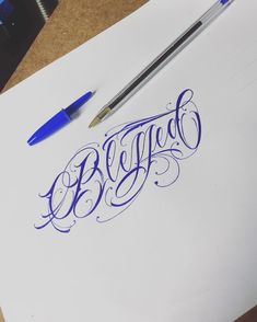 a pen and some writing on top of a piece of paper with the word blyggd written in blue ink