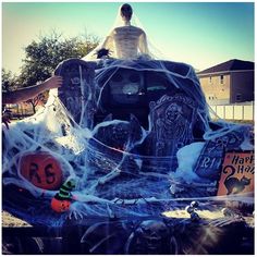 a man is sitting on top of a car decorated for halloween