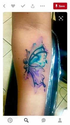 a colorful butterfly tattoo on the left arm and leg, with watercolor splashes all over it