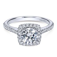 a cushion cut diamond halo engagement ring with pave set diamonds on the shans