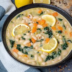 a bowl of white bean soup with lemons, spinach and bread on the side